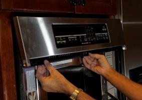 Push the microwave back into place.  Then carefully slide the upper trim plate under the upper face plate so you can screw it down.